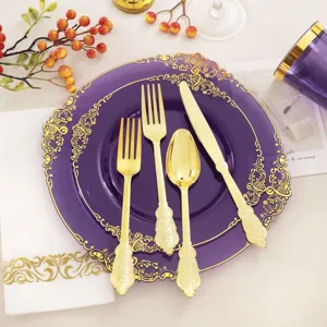 Gros plan d'assiettes en plastique violettes avec bords dorés et ensemble de couverts dorés