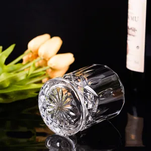 Elegant crystal whiskey glass with engraved pattern and heavy base in a dark setting