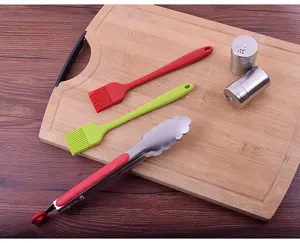 Detail of BBQ tool set including stainless steel tongs and silicone oil brushes