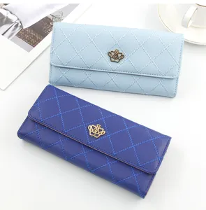 Close-up of elegant quilted long wallets in blue colors featuring gold crown metal emblem
