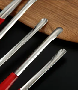 Detailed view of serrated stainless steel kitchen food tongs with red rubber handles