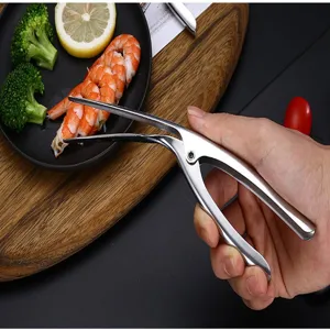 Gros plan d'un éplucheur de crevettes en inox retirant la carapace d'une crevette
