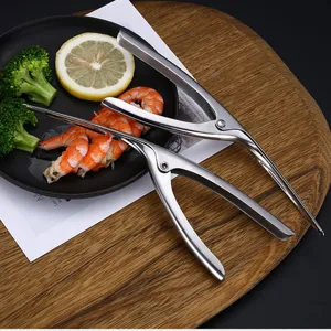 Éplucheur de crevettes en acier inoxydable 304 avec des crevettes cuites sur une assiette