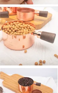 Macro detail of rose gold stainless steel measuring cup with elegant walnut wood handle