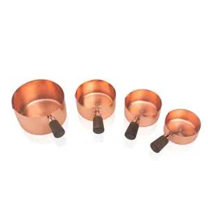 Set of four rose gold stainless steel measuring cups with elegant walnut wood handles