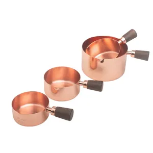 Detailed view of rose gold stainless steel measuring cups with walnut wood handles