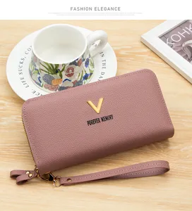 Détail d'un portefeuille long en cuir grainé rose poudré avec un logo en V doré élégant