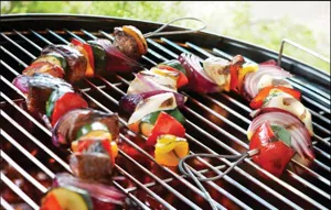 Detalle de brochetas de alambre de acero inoxidable flexible para barbacoa con comida.