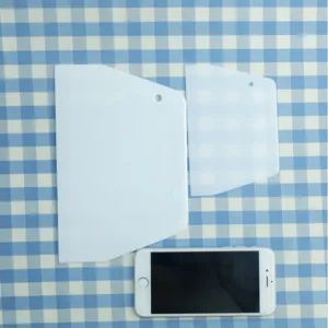Lot de deux racloirs à pâte en plastique blanc, avec un smartphone pour comparer la taille