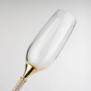 Dettaglio squisito di un calice da champagne con bordo dorato e stelo con cristalli