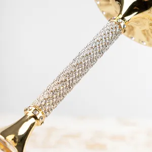 Dettaglio ravvicinato dello stelo dorato di un calice con strass lussuosi e brillanti