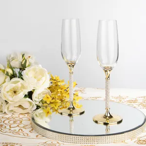 Dettaglio di due eleganti flauti da champagne in acciaio inox con steli in cristallo dorato