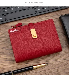 Detailed view of red pebbled leather women's short wallet with elegant gold buckle