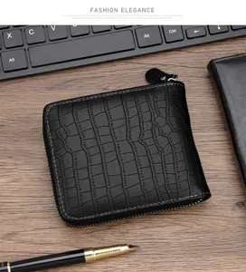 Cartera negra para hombre con patrón de cocodrilo y cremallera en un escritorio de madera