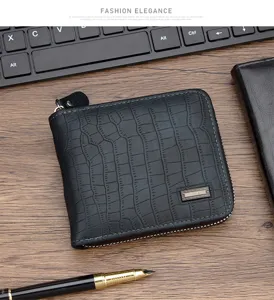 Detalle de una cartera negra para hombre con patrón de cocodrilo y cremallera.