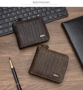 Vista detallada de dos carteras marrones para hombre con motivo de cocodrilo y cremallera