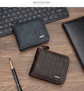 Primer plano de carteras de hombre con cremallera y textura de cocodrilo en un escritorio
