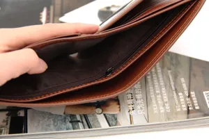 Interior detail of a men's brown leather bifold wallet with zipper pocket