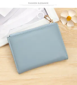 Detailed view of a light blue faux leather women's small wallet with gold zipper