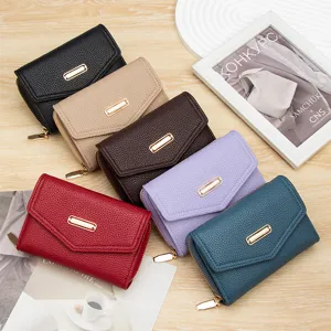 Variedad de carteras cortas para mujer en cuero granulado con adornos dorados.