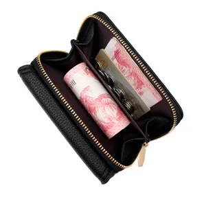 Vista interior del monedero de cuero negro con cremallera, ranuras para tarjetas y monedas.