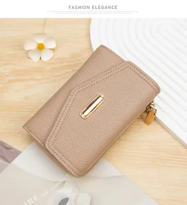 Detalle de una cartera para mujer color topo con patrón de lichi y hebilla dorada fina