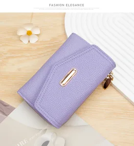Primer plano de cartera de mujer en cuero violeta con grano de litchi y cremallera dorada