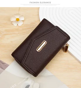 Detalle de una cartera corta para mujer en cuero marrón oscuro con hebilla dorada.