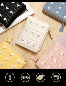 Close-up of small embroidered flower zip wallets in various pastel and classic colors.