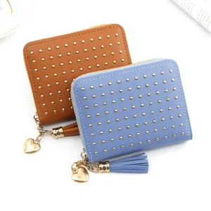 Close-up of stylish women's coin purses in tan and blue with gold studs and heart charm