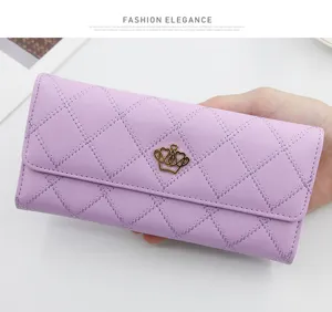 Detail view of purple diamond-stitched women's wallet with gold crown ornament