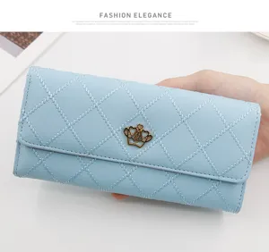 Close-up view of a light blue quilted long wallet featuring a golden crown logo on the flap