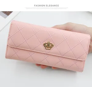 Close-up of pink quilted long wallet for women featuring a gold crown metal ornament