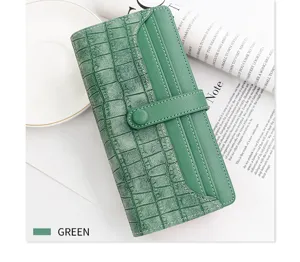 Vue détaillée d'un grand portefeuille pour femme vert avec texture crocodile chic