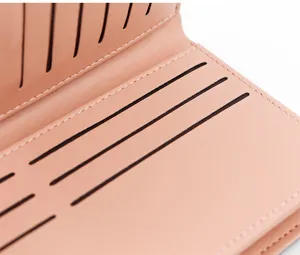 Gros plan sur les fentes pour cartes internes d'un portefeuille rose minimaliste