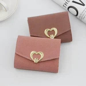 Detailed view of elegant small tri-fold wallets with golden heart-shaped clasps.