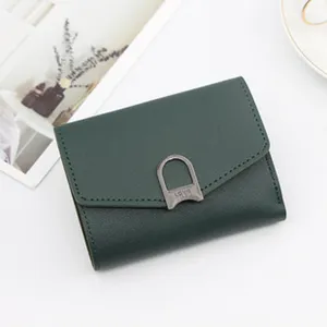 Close-up of a dark green tri-fold women's wallet with 'LOVE' engraved metal clasp