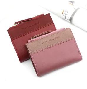Détail de deux portefeuilles courts pour femmes en rouge et rose à texture mate.