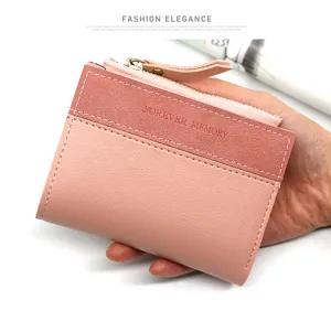 Gros plan d'un portefeuille court rose mat bicolore élégant avec fermeture éclair.