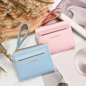 Vista detallada de carteras para tarjetas rosa y azul con textura de cuero y correa.