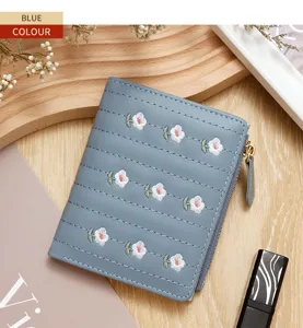 Detail view of blue embroidered floral wallet with zipper closure and fine stitching