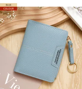 Vue détaillée d'un portefeuille bleu en cuir texturé pour femme avec porte-clés.
