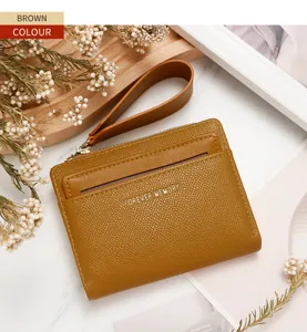 Detalle de una elegante cartera con cremallera de cuero granulado marrón con correa