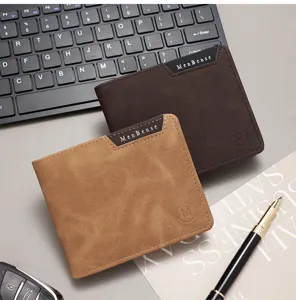 Portafoglio bifold da uomo in pelle marrone con penna stilografica su una tastiera