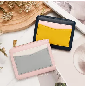 Detail of two color-blocking leather wallets with card slots and a metal zipper