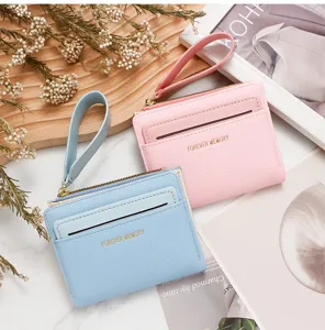 Detalle de cerca de carteras para tarjetas con cremallera para mujer en azul y rosa con correas
