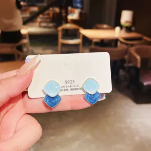 Close-up detail of vintage blue geometric enamel stud earrings on a display card