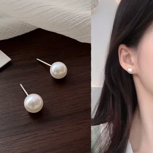 Detailed view of elegant round pearl stud earrings with silver needles for women