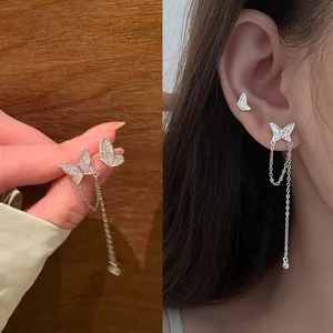 Close-up of elegant butterfly stud earrings with delicate dangling silver chains