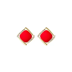 Detailed view of elegant red matte square stud earrings with gold plating and crystals.